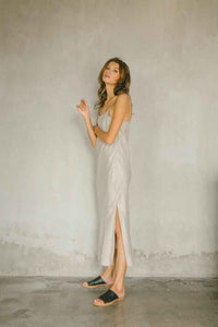 A relaxed maxi dress made from 100% linen in natural color with high slit
